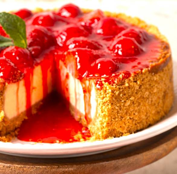 Erdbeer-Käsekuchen mit frischen Erdbeeren garniert angeschnitten auf einer Kuchenplatte, Erdbeersauce tropft hinunter