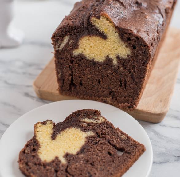 Hasenkuchen aus Schokoteig in der Kastenform gebacken angeschnitten mit hellem Hasenmotiv auf einem Teller