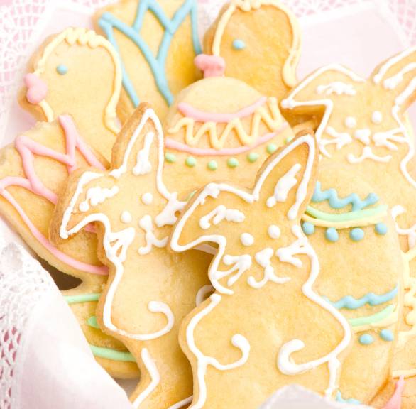 Verzierte Osterkekse in Form von Ostereiern, Hasen und Enten in einem Körbchen