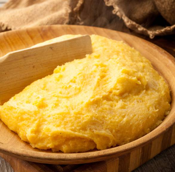 Gekochte Polenta nach Grundrezept in einer Holzschüssel