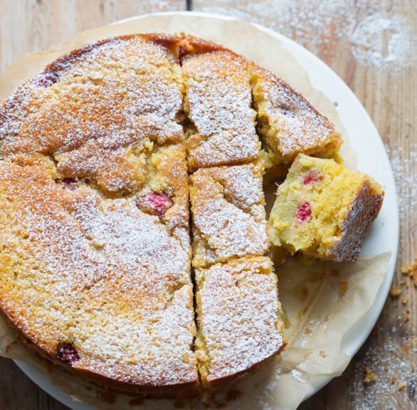 Runder Rhabarber-Polenta-Kuchen angeschnitten auf einem Teller