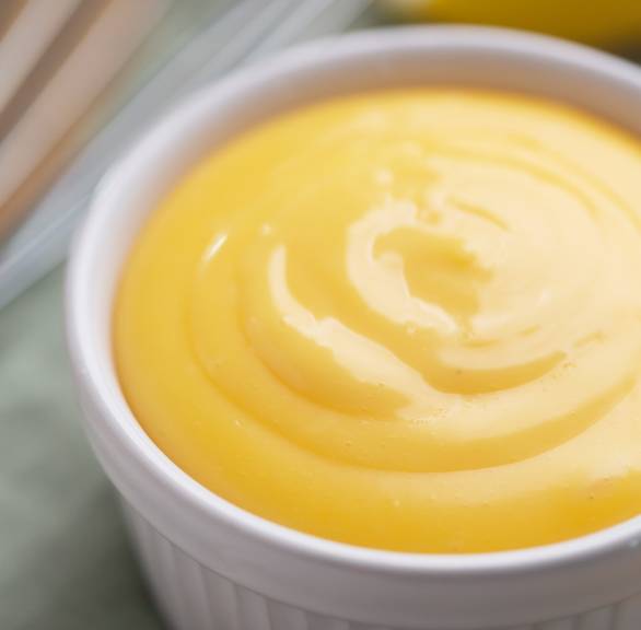 selbst gemachtes Aioli in einer kleinen Schale, daneben Zitrone und Knoblauch
