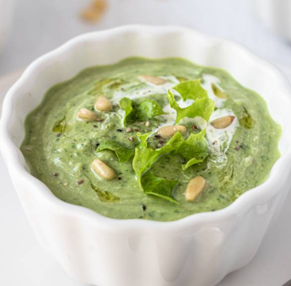 Avocado-Suppe in einer Suppenschale getoppt mit Pinienkernen und Minzblättern