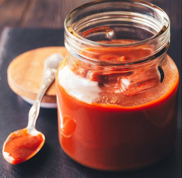 BBQ-Sauce mit Ramazotti in einem Einmachglas, daneben ein Löffel
