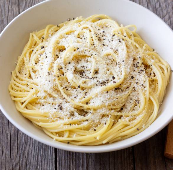 Spaghetti Cacio e pepe mit geriebenem Pecorino und schwarzem Pfeffer in einem tiefen Teller