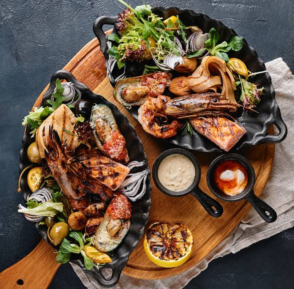 Schwertfisch und verschiedene Meeresfrüchte gegrillt angerichtet auf einer Platte