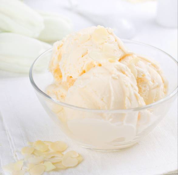 Drei Kugeln Low-Carb-Vanille-Mandel-Eis in einem Glasschälchen getoppt mit Mandelblättchen