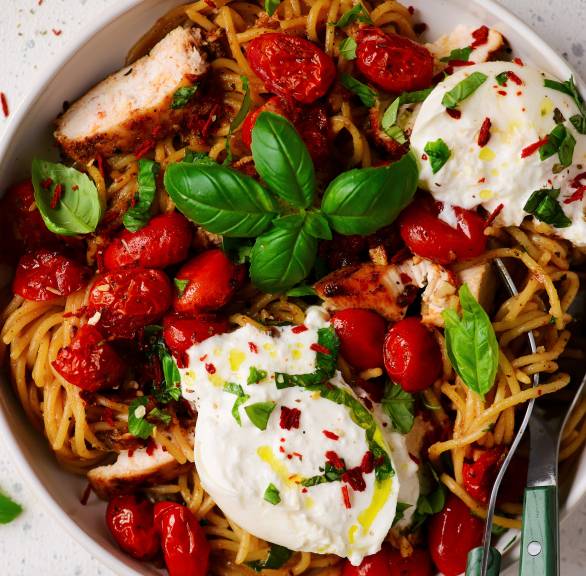 One-pot-Spaghetti mit Hähnchen, Cherrytomaten, getoppt von Burrata und Basilikum in einem tiefen Teller