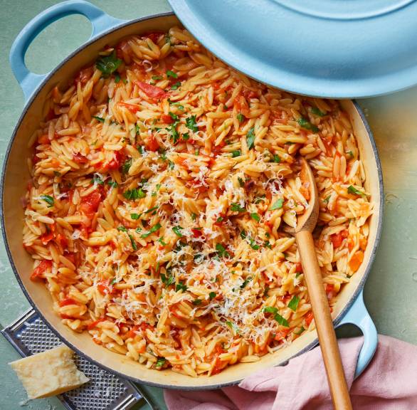Topf mit One-Pot-Risoni, Tomatensoße, Feta und Parmesan auf einem Tisch