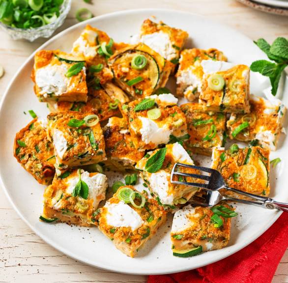 Frittata-Häppchen mit Zucchini und Käse gestapelt auf einem Teller