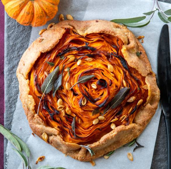 Crostata mit Kürbisfüllung von oben auf einem Tisch, darauf Kürbiskerne als Topping