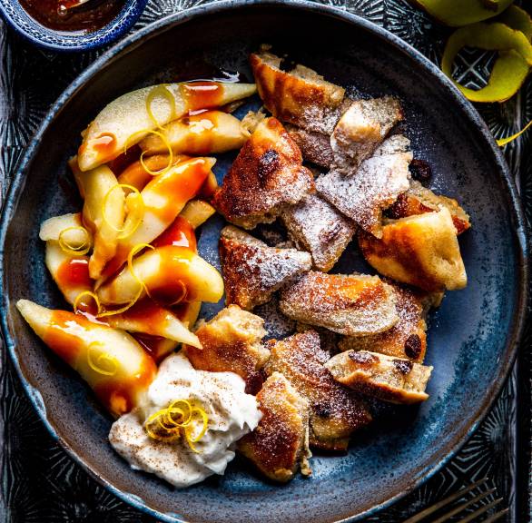 Kaiserschmarrn mit Birnen, karamellsoße und Sahne angerichtet auf einem Teller
