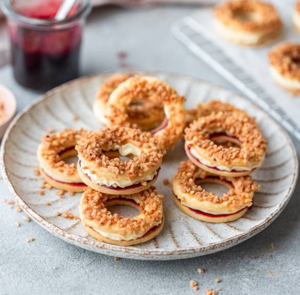 Mehrere Krokant-Buttercreme-Ringe auf einem Plätzchenteller