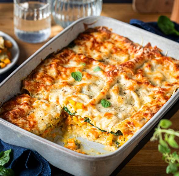 Kürbislasagne mit Spinat und Mozzarella angeschnitten in einer Auflaufform