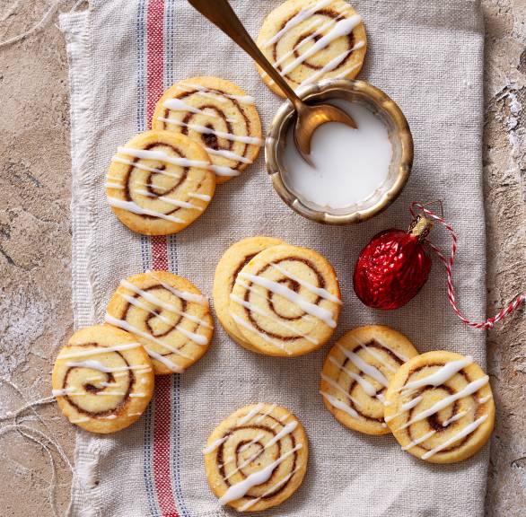 Merere Zimtschnecken-Plätzchen mit weißem Guss auf einem Küchentuch