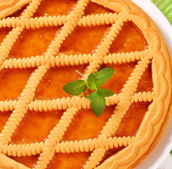 Runder italienischer Marmeladenkuchen mit Gitter auf einer Kuchenplatte