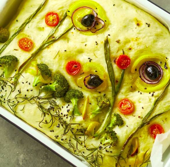 Selbst gebackener Focaccia-Garden bunt belegt mit Gemüse als Blumen 