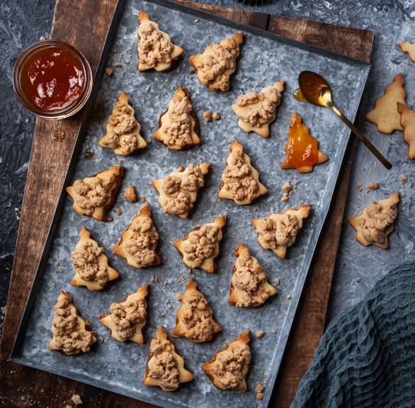 Selbst gebackene Doppeldecker-Tannenbaum-Plätzchen mit Zimtsreuseln auf einem Backblech