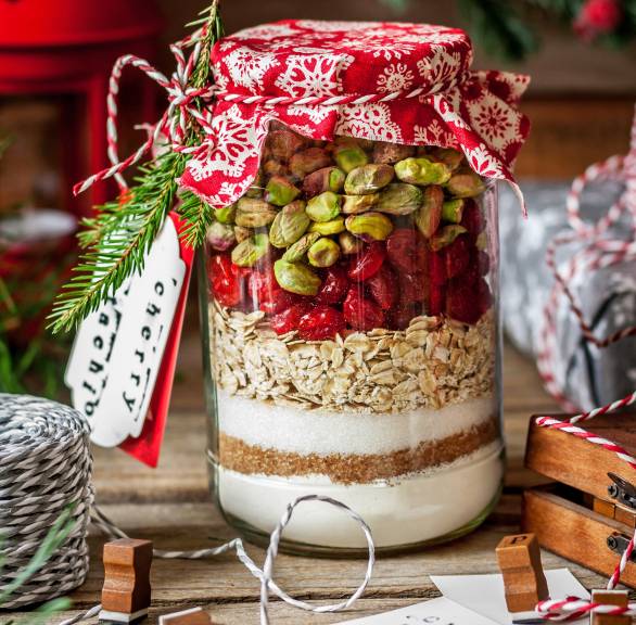 Backmischung für Hafer-Cookies mit Pistazien und Kirschen geschichtet in ein Weckglas und weihnachtlich verpackt