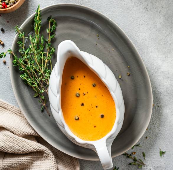 Selbst gekochte Pfeffersauce in einer Sauciere auf einem Tisch von oben