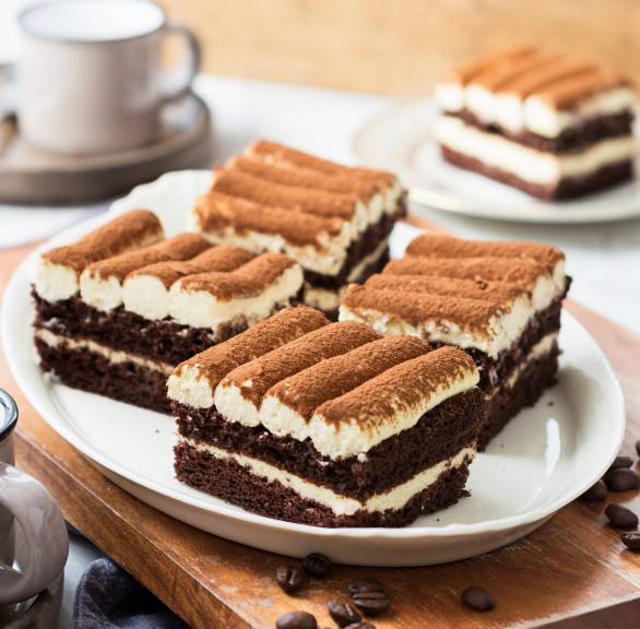 Vier Stücke Tiramisu-Kuchen auf einer Kuchenplatte