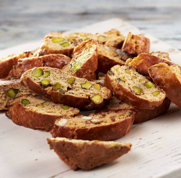Selbstgebackene Pistazien-Cantuccini auf einem Holzbrett