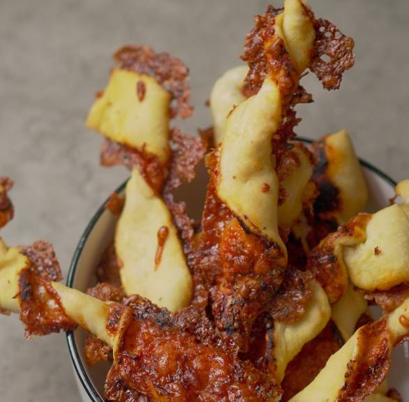 Selbstgebackene Pizzastangen aufrecht in einer Schale auf einem Tisch