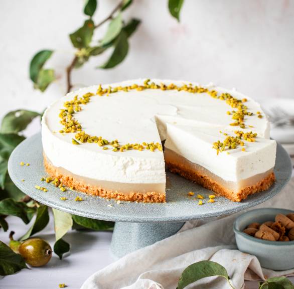 Runde Birnen-Ricotta-Torte ohne Backen mit Keksboden auf einer Tortenplatte