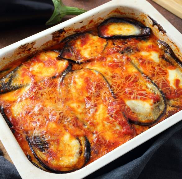 Aufberginenauflauf Melanzane alla Parmigiana in einer Auflaufform auf einem Tisch