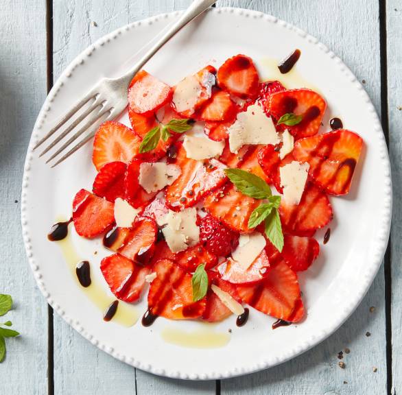 Erdbeer-Carpaccio angerichtet auf einem Vorspeisenteller mit Parmesan und Minze