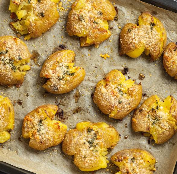 Ein Blech mit gebackenen Italian Smashed Potatoes mit Parmesan-Knoblauch-Kruste