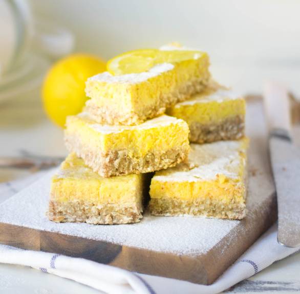 Glutenfreie Lemon Bars ohne Backen gestapelt auf einem Holzbrett