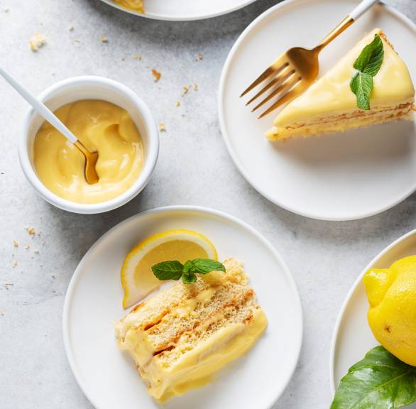 Zwei Stücke Limoncello-Zitronen-Schichttorte auf Kuchentellern