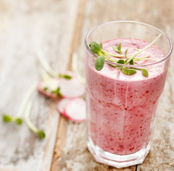 Selbstgemixter Radieschen-Buttermilch-Drink in einem Glas garniert mit Kresse auf einem Holztisch