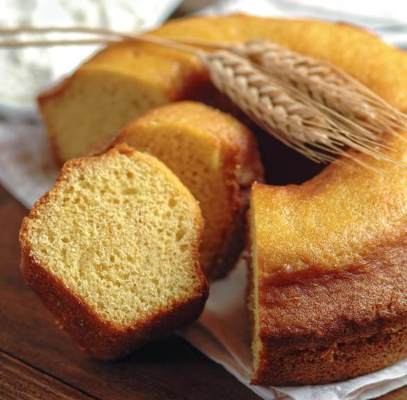 Ciambellone italienischer Zitronen-Rührkuchen angeschnitten auf einem Holzbrett