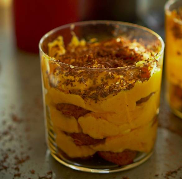 Kürbis-Tiramisu in zwei Dessertgläser geschichtet auf einem für Halloween dekorierten Tisch
