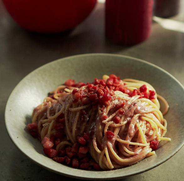 Spaghetti angerichtet mit lila Carbonara angerichtet auf einem Pastateller mit Speck und Käse