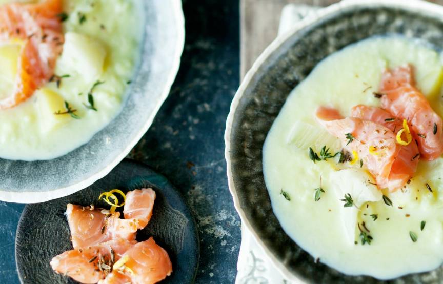 Blumenkohlsuppe mit Fenchel in zwei Schüsseln getoppt mit Räucherlachs und Kräutern auf einem Tisch