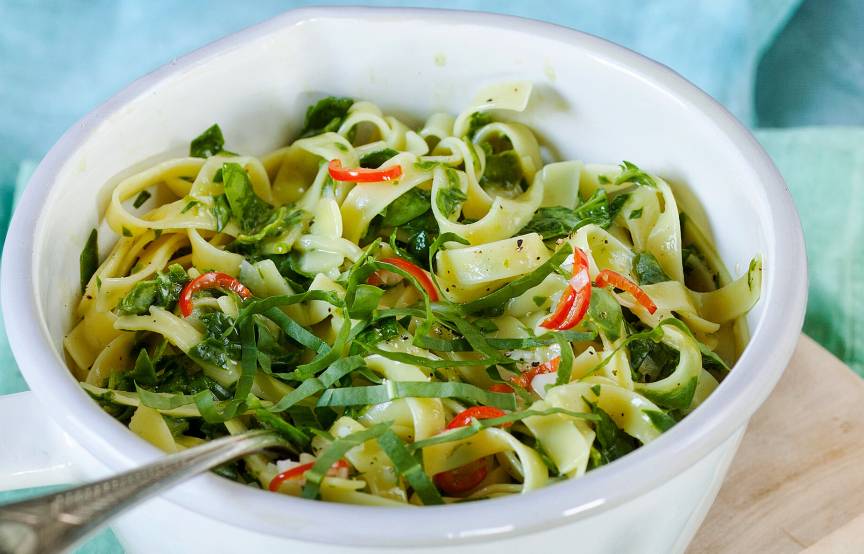 Bärlauchnudeln in einem Topf getoppt mit frischem Bärlauch, Peperoncino-Streifen und Parmesan