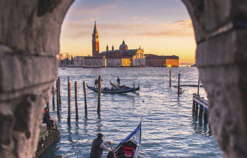 Blick durch ein altes Fenster auf die Wasserstraßen von Venedig