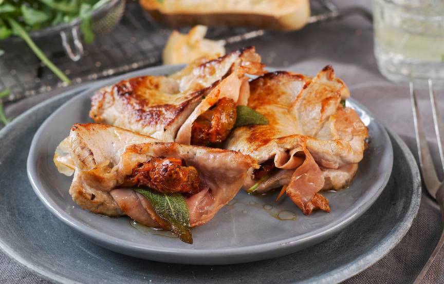 Saltimbocca vom Kalb eingewickelt in Schinken auf einem Teller