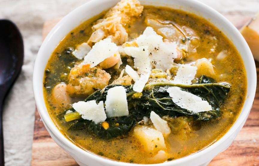 Kohlsuppe in einer Suppenschale mit Einlage aus Brot und Kohl getoppt mit Parmesanspänen
