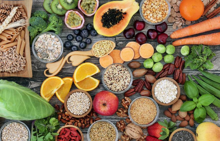 Ballaststoffreiche Lebensmittel auf einem Holztisch von oben