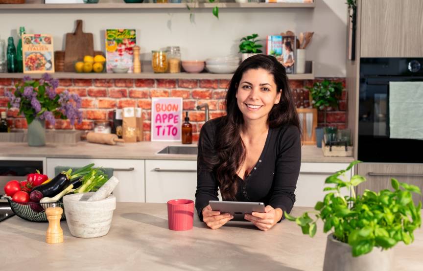 Serena Loddo in der So isst Italien Küche schaut via Tablet in den WhatsApp-Kanal