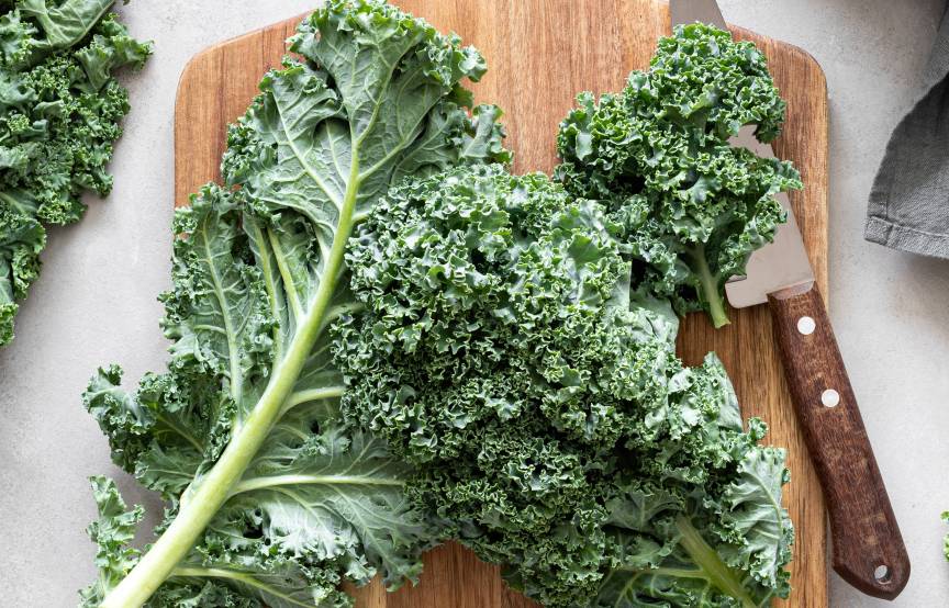 Frische Grünkohlblätter auf einem Holzbrett