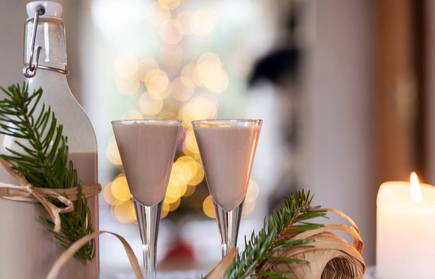 Selbst gemachter Weihnachtslikör in einer hübsch verpackten Glasflache auf einem Tisch