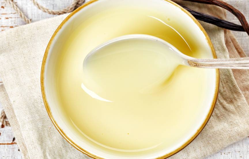 Selbst gekochte Vanillesoße in einer Sauciere wird gerade umgerührt