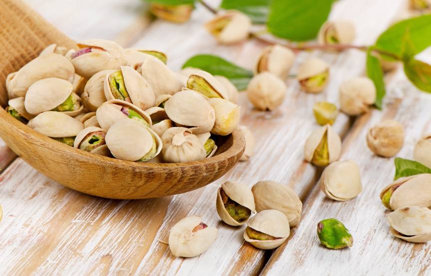 Ungeschälte Pistazien auf einem Holzlöffel