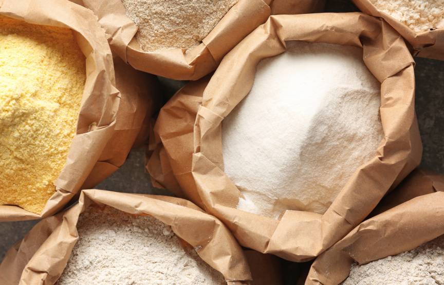 Verschiedene Mehlsorten in Papiertüten auf einem Tisch von oben