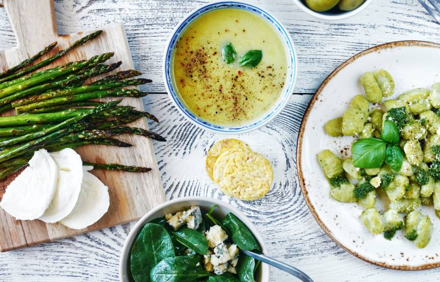 Gnocchi mit verschiedenen Beilagen wie grünem Spargel, Mozzarella und Oliven auf einem Tisch